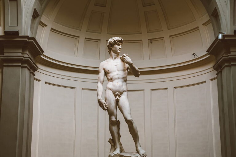 The original marble statue of Michelangelo's David standing under the skylight tribune at the Accademia Gallery during a Baroque Bacchus private tour in Florence