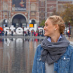 Smiling blonde female traveler looking to the side outdoors, sharing a positive review after a bespoke Baroque Bacchus tour experience